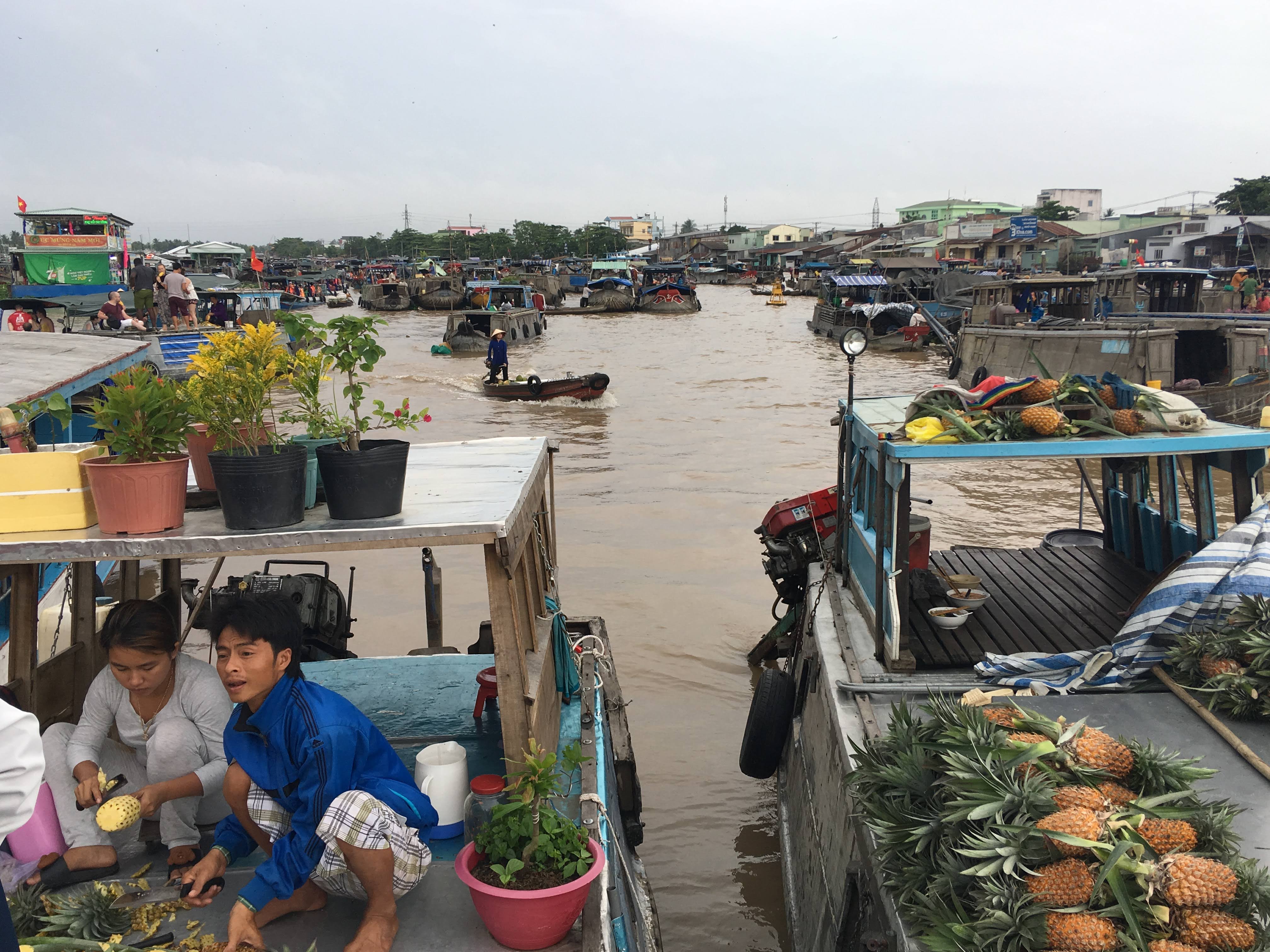 Boats carrying produce and vendors at Cai Rang Floating Market in Can Tho